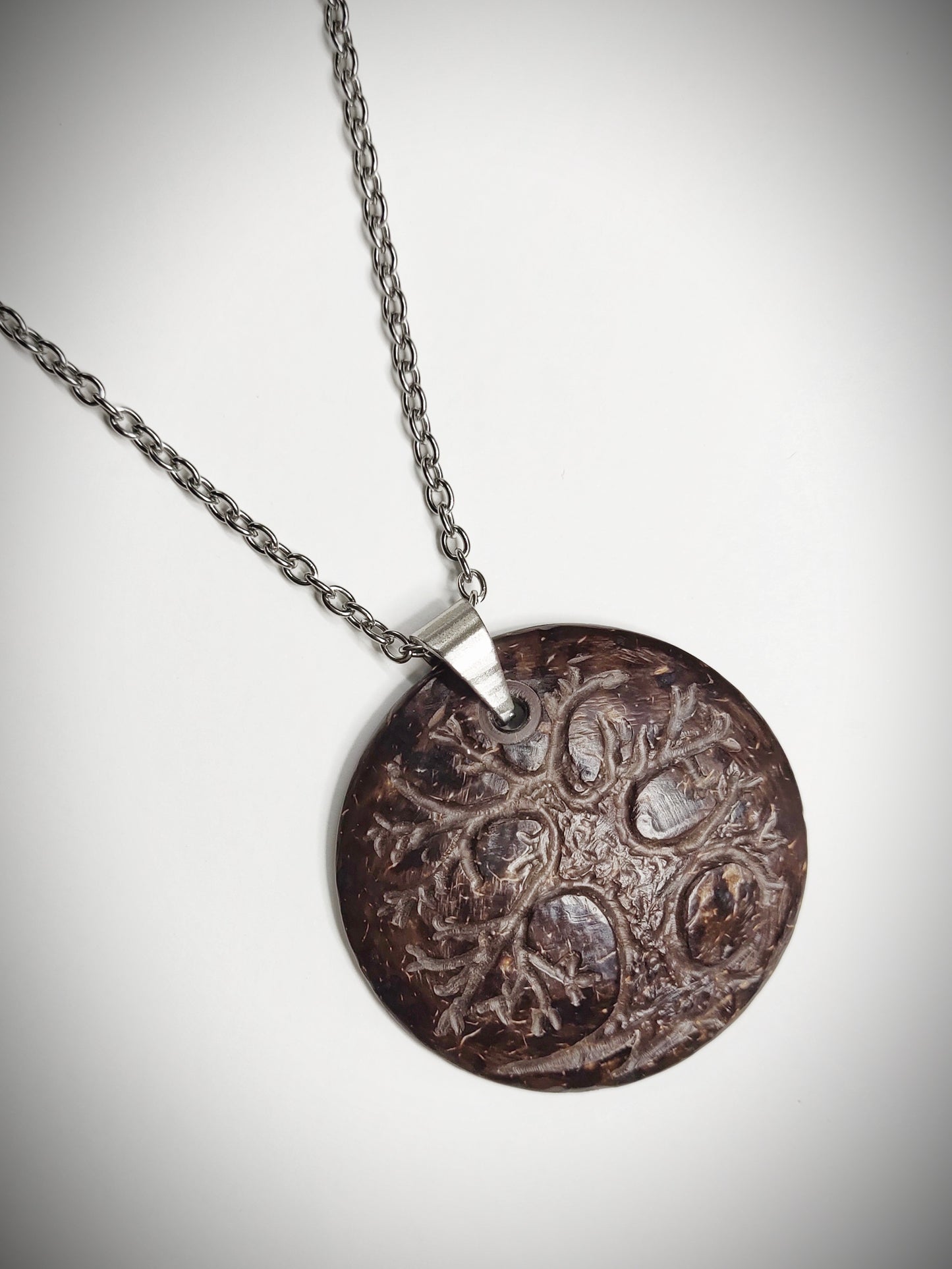A one of a kind coconut shell pendant with stainless steel chain