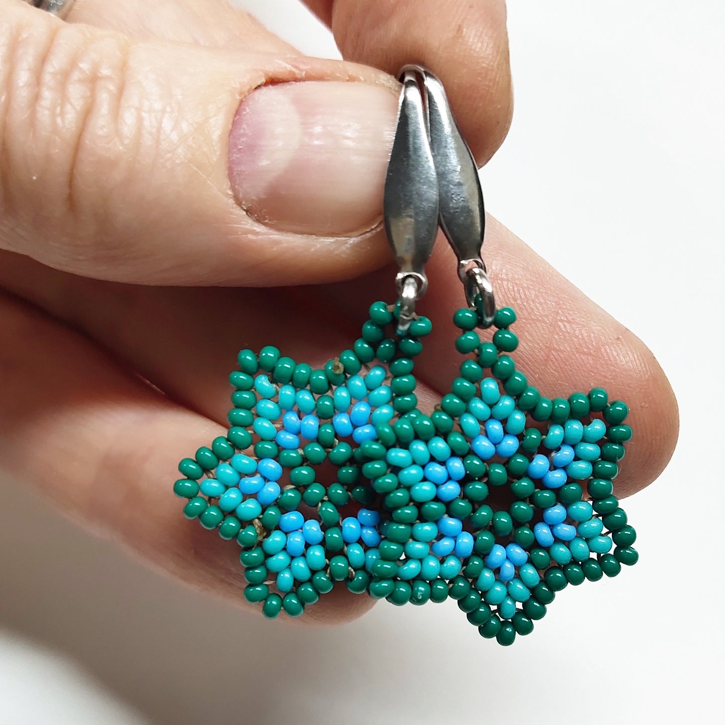 Dark bluish green beaded star earrings