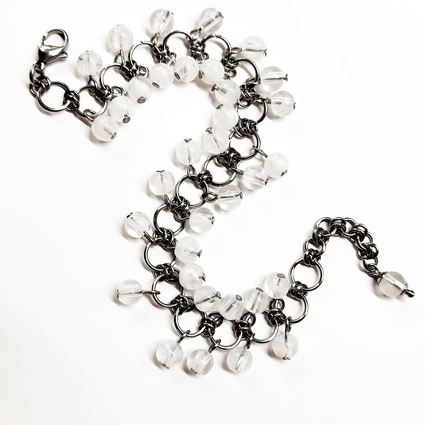 A set of clear and white beads bracelet and dangling earrings