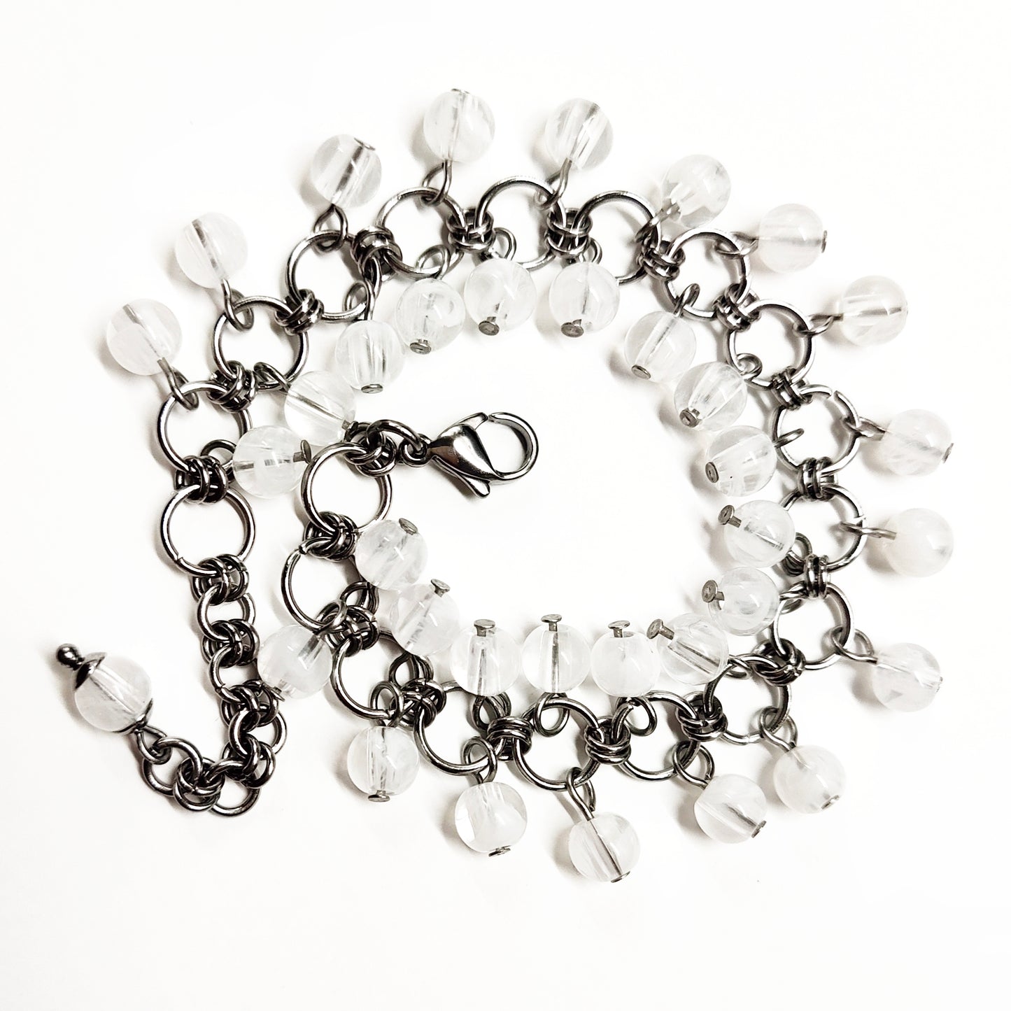 A set of clear and white beads bracelet and dangling earrings