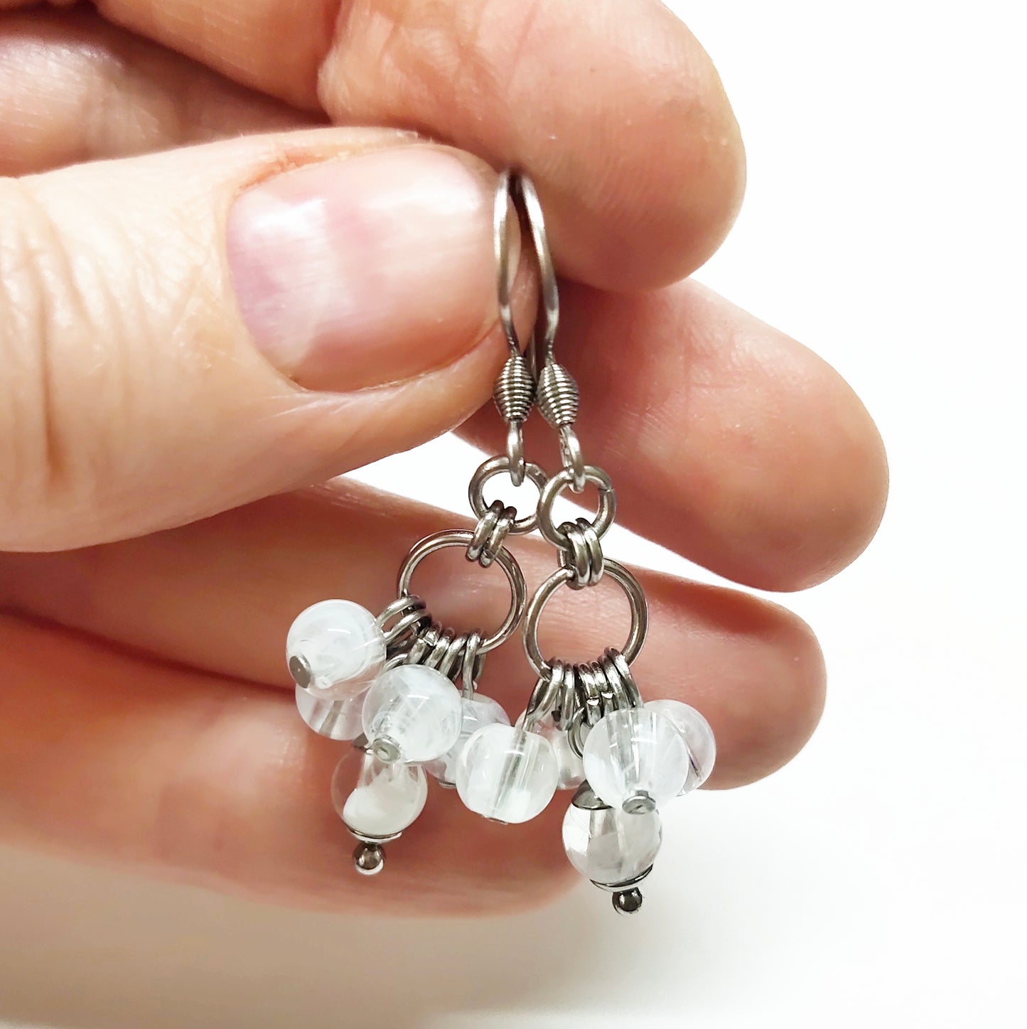 A set of clear and white beads bracelet and dangling earrings