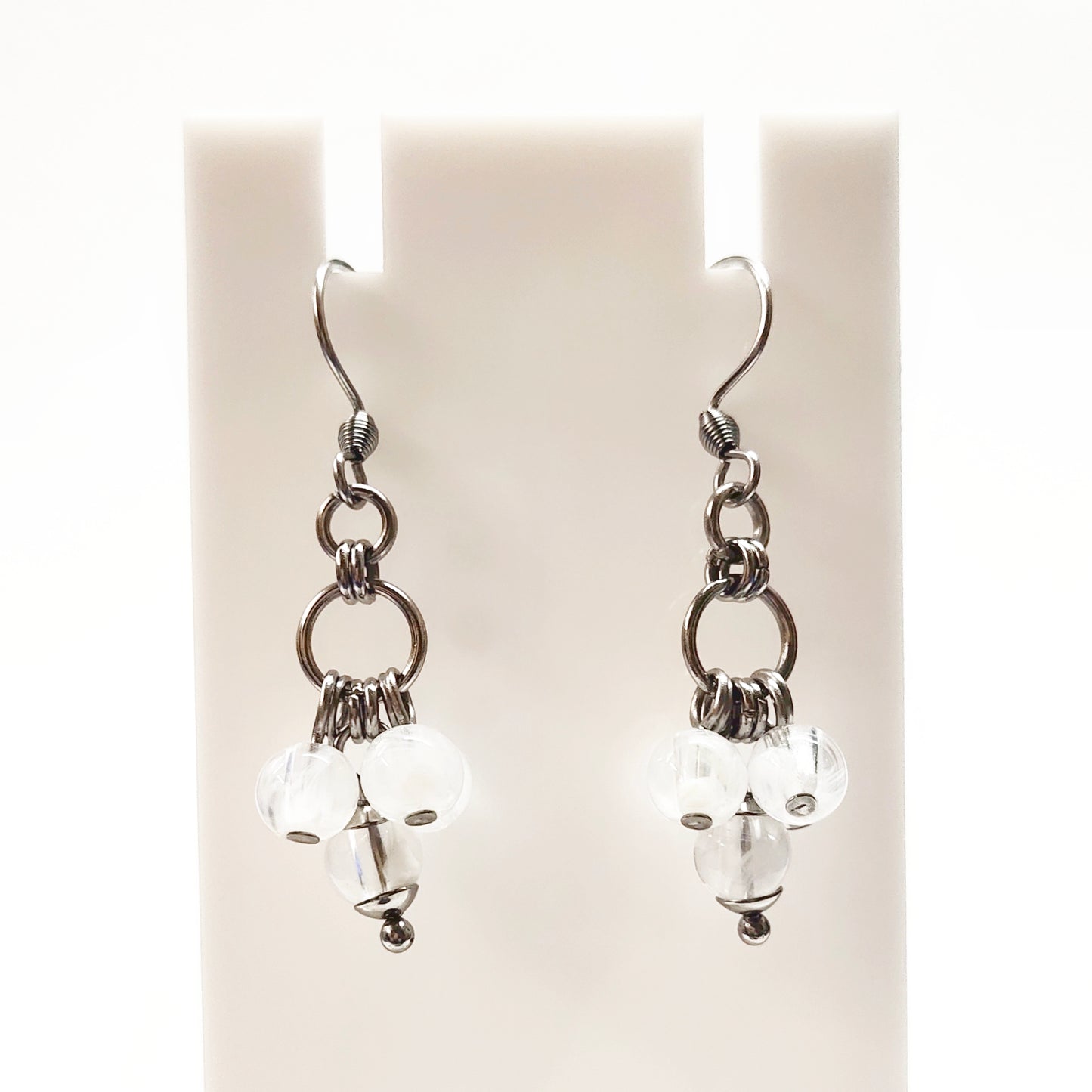 A set of clear and white beads bracelet and dangling earrings