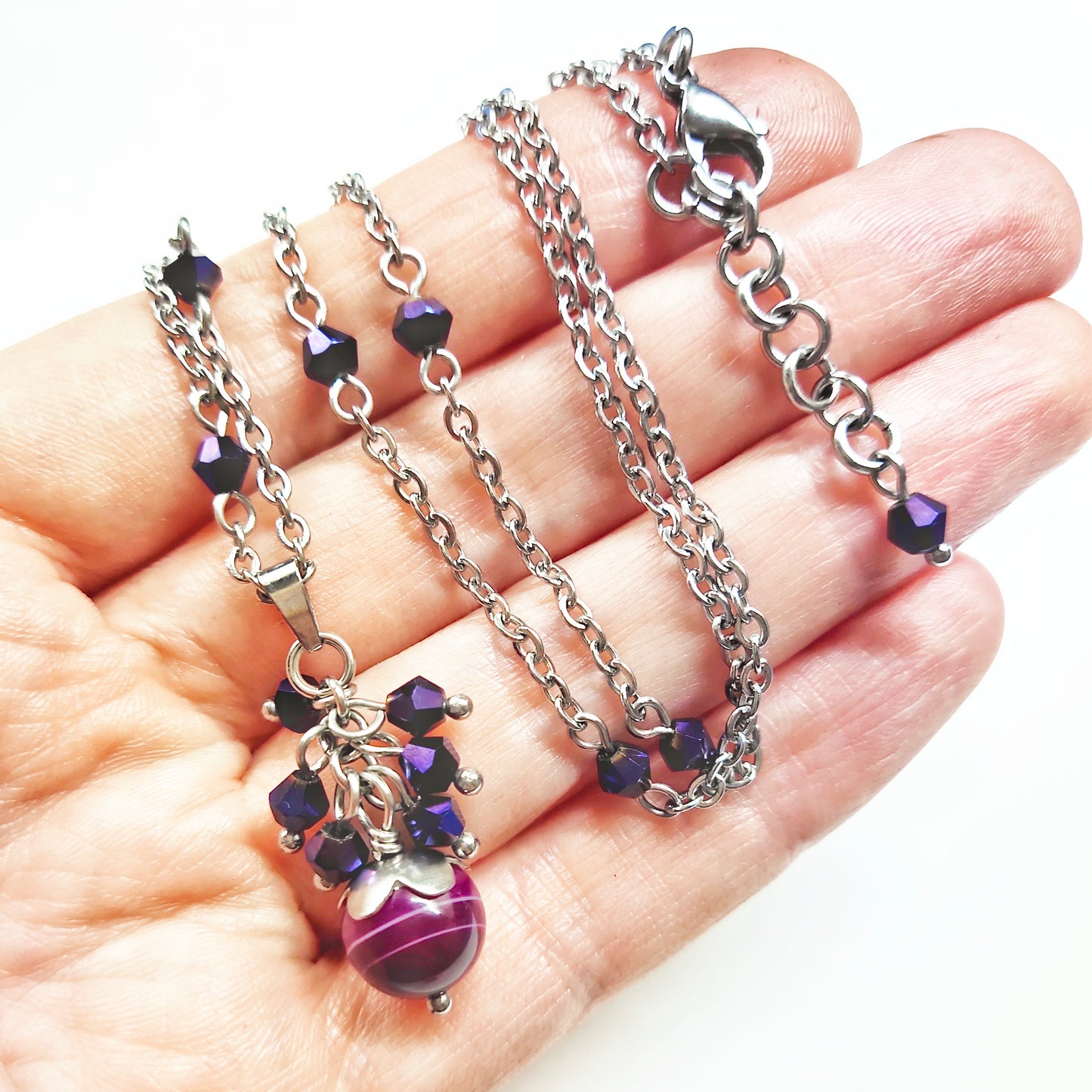 A set of magenta and purple beads necklace and earrings