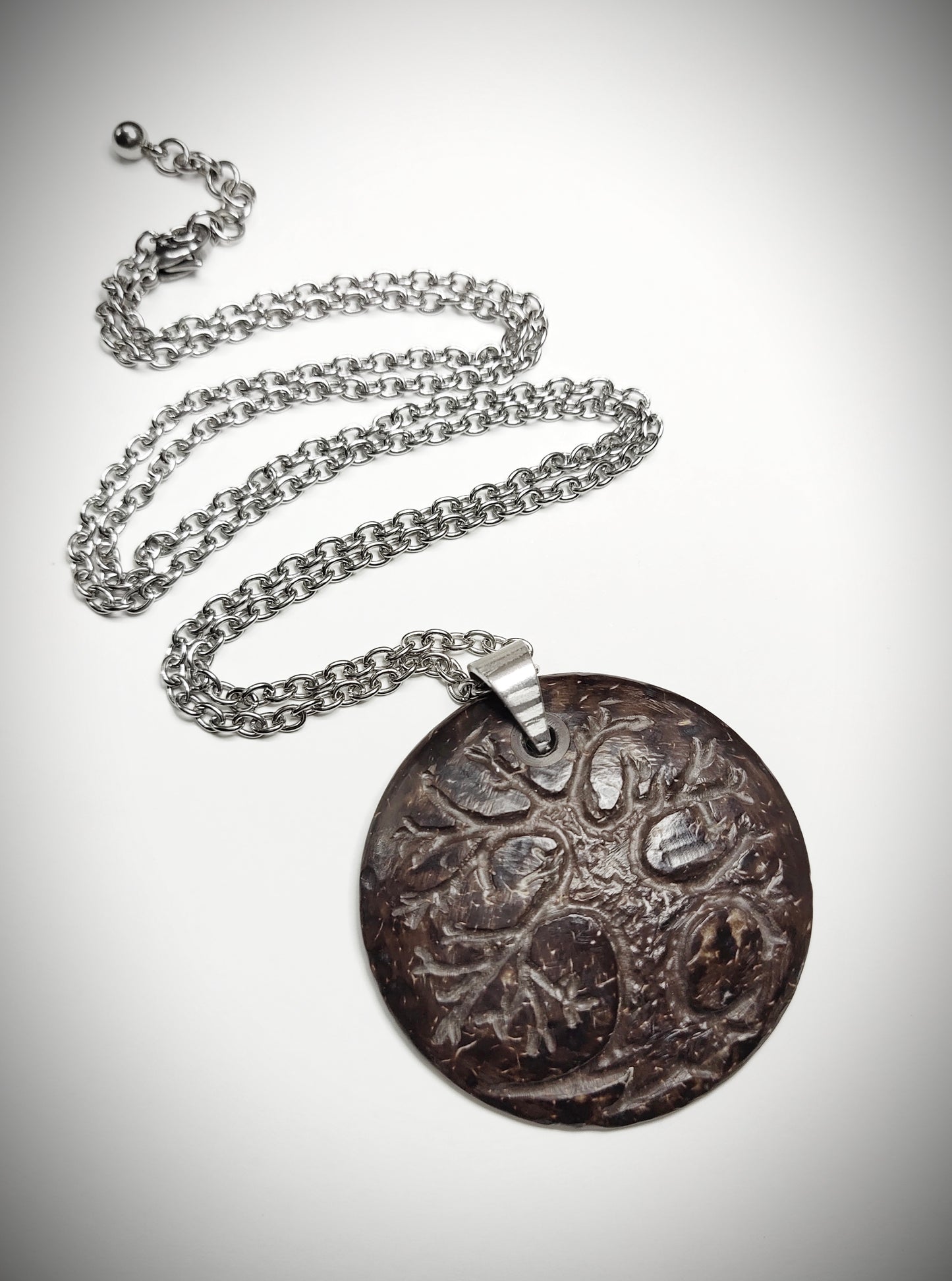 A one of a kind coconut shell pendant with stainless steel chain