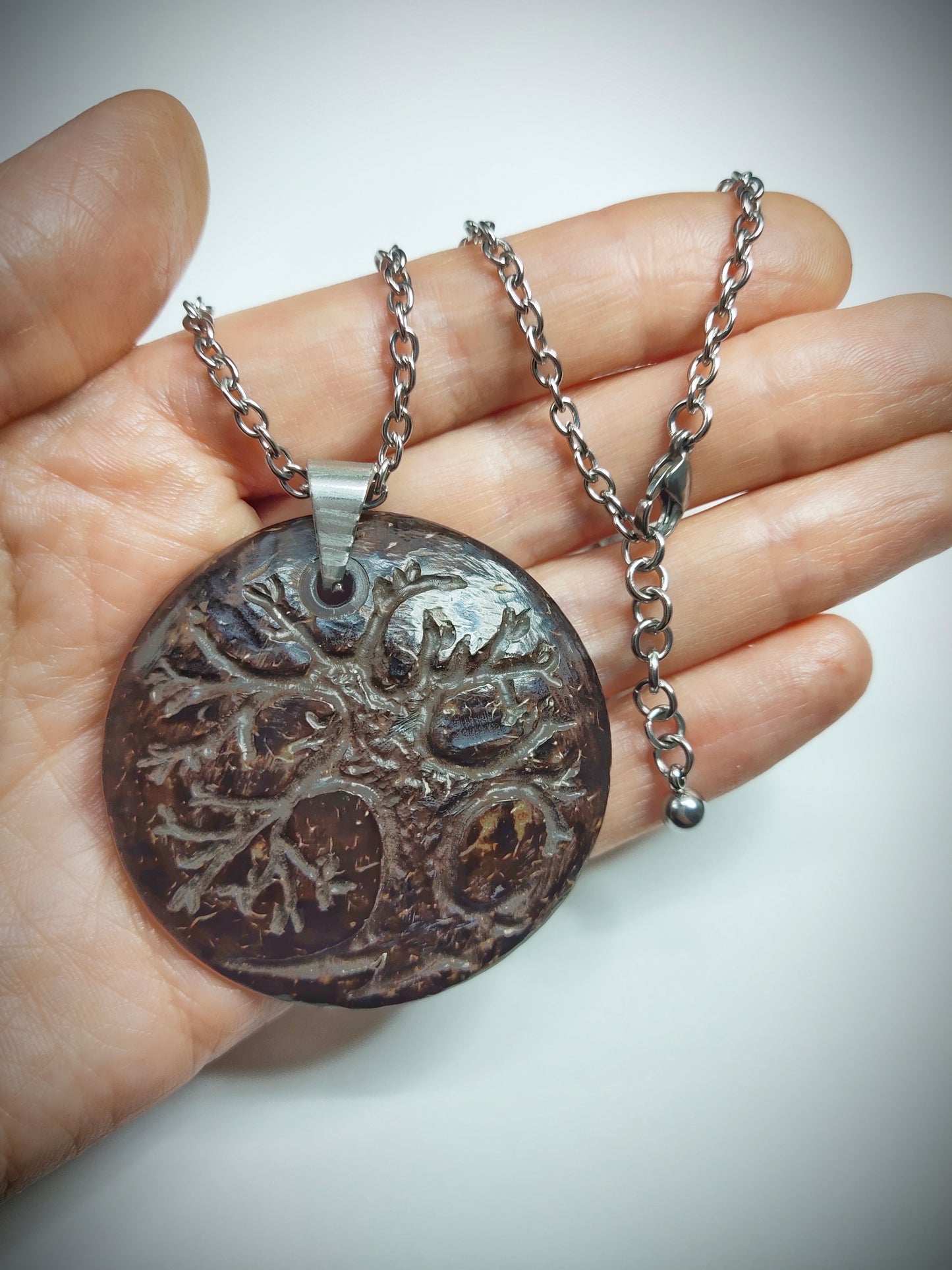 A one of a kind coconut shell pendant with stainless steel chain