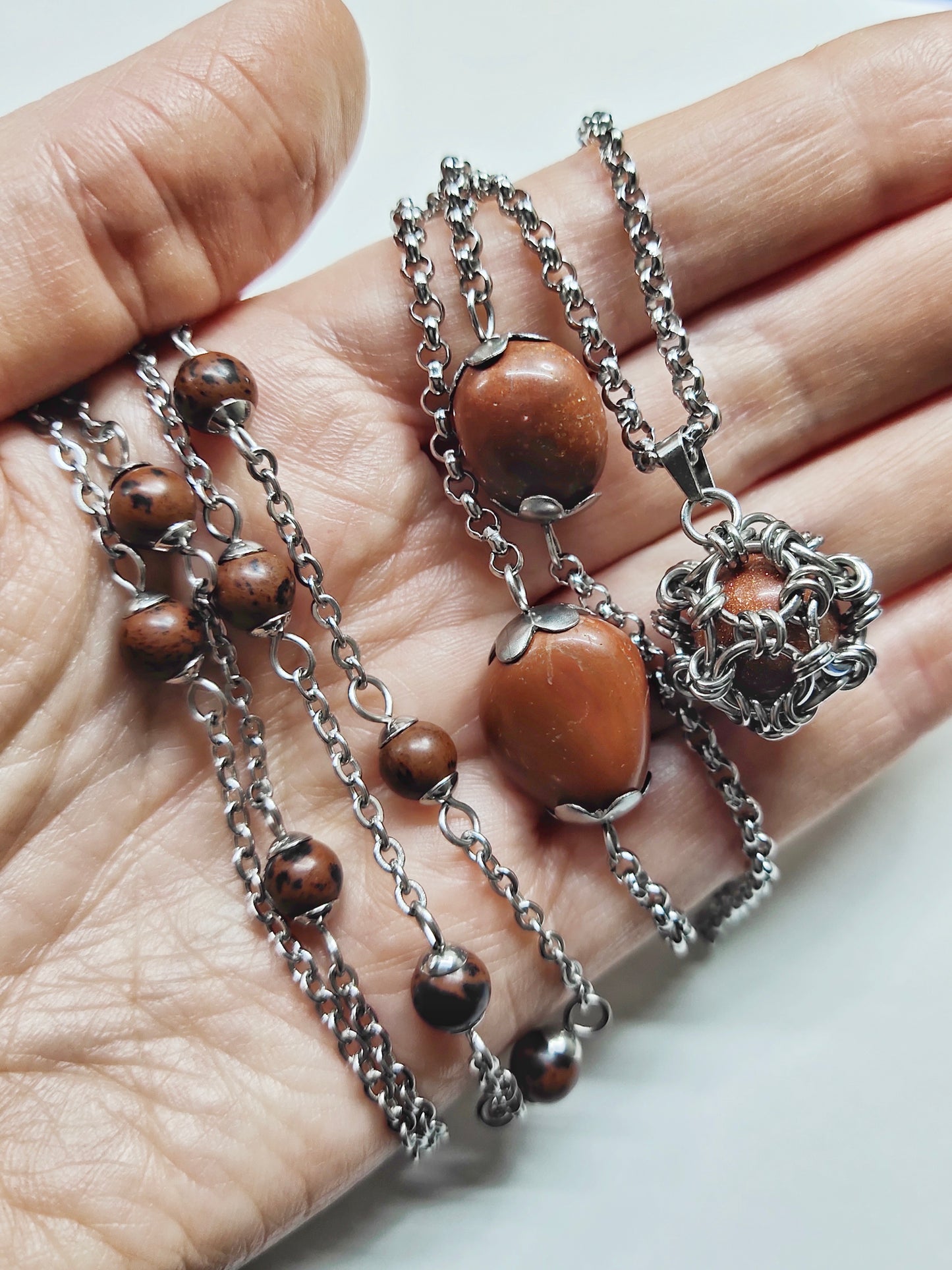 Two long matching necklaces with rusty brown beads, stones and a pendant #0009