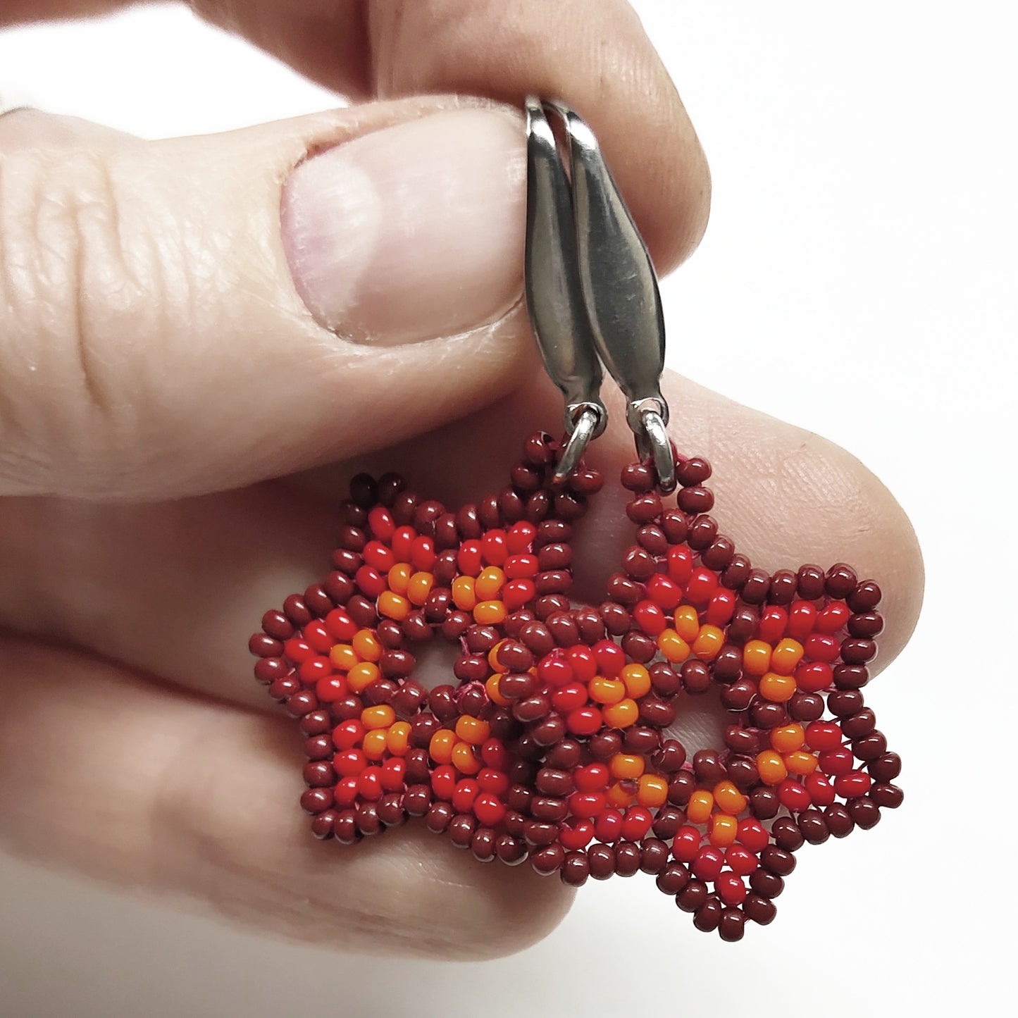 Reddish brown, red and orange beaded star earrings